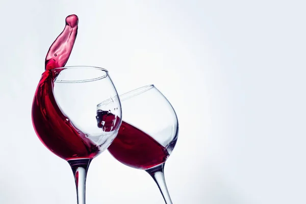 Twee wijnglazen in roosteren gebaar met grote spatten. — Stockfoto
