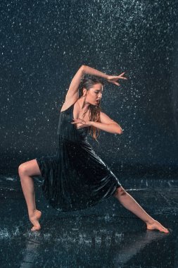 Genç güzel modern dansçı su damlaları altında