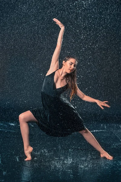 Die junge schöne moderne Tänzerin tanzt unter Wassertropfen — Stockfoto