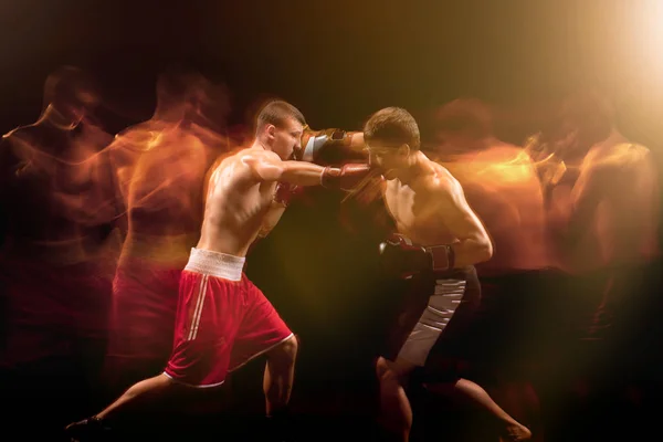 两名男性拳击手拳击在一个黑暗的工作室 — 图库照片