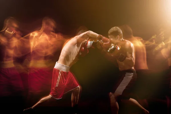 The two male boxers boxing in a dark studio — Stock Photo, Image