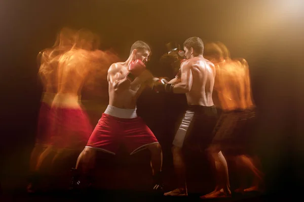 The two male boxers boxing in a dark studio — Stock Photo, Image