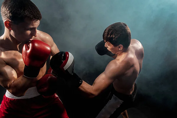 Two professional boxer boxing on black smoky background, — Stock Photo, Image