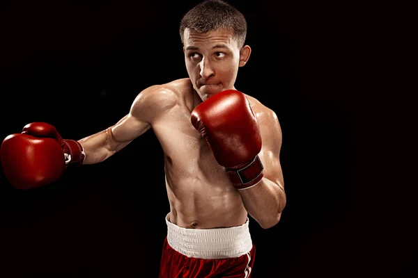 Male boxer boxing with dramatic edgy lighting in a dark studio — Stock Photo, Image