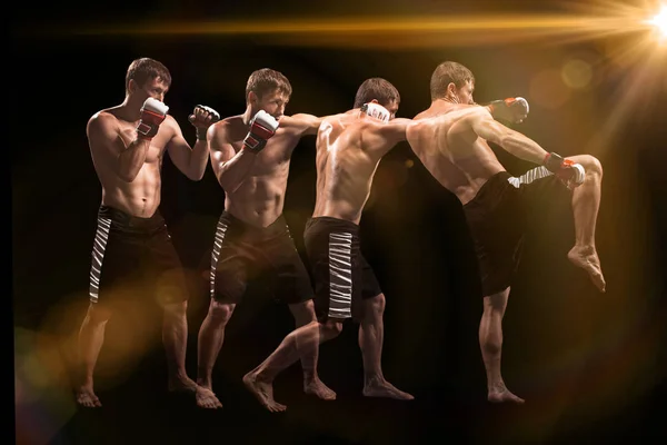 Male boxer boxing in punching bag with dramatic edgy lighting in a dark studio — Stock Photo, Image