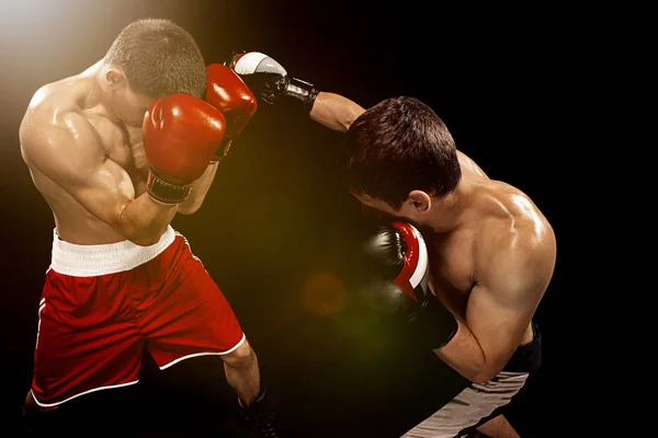 Two professional boxer boxing on black background, — Stock Photo, Image