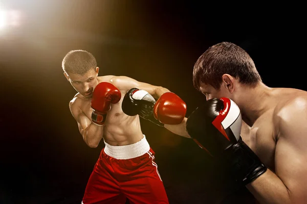 Två professionella boxare boxning på svart bakgrund, — Stockfoto