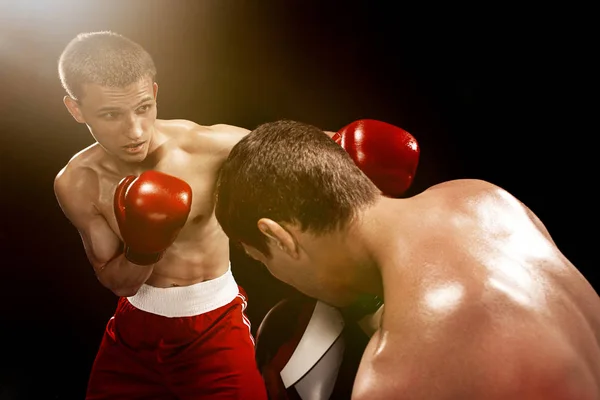 Zwei professionelle Boxer boxen auf schwarzem Hintergrund, — Stockfoto