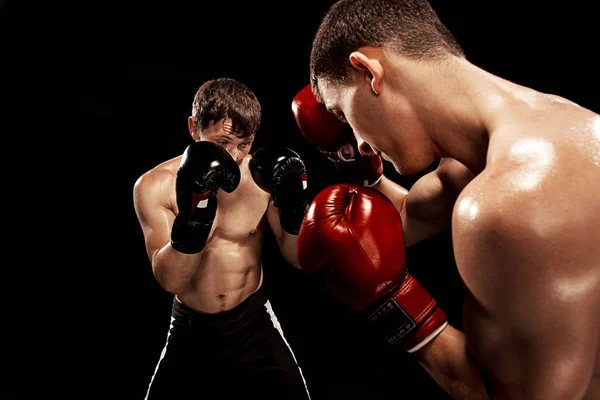 Dos boxeadores profesionales boxeando sobre fondo negro , — Foto de Stock