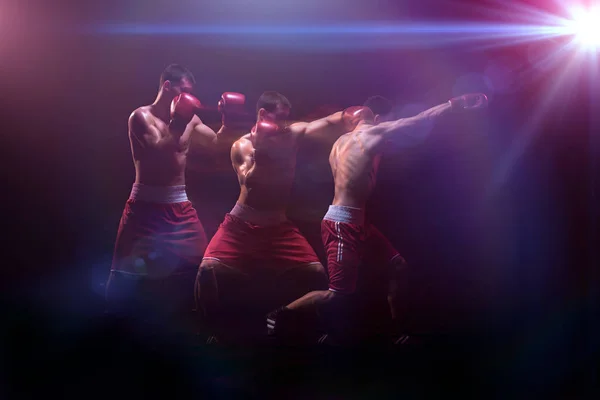 Nyrkkeilijä nyrkkeily pimeässä studiossa — kuvapankkivalokuva