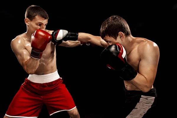 Dos boxeadores profesionales boxeando sobre fondo negro , — Foto de Stock