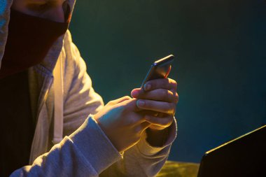 Kapüşonlu bilgisayar korsanı laptopla bilgi çalıyor