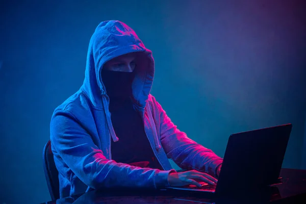 Hacker de computador com capuz roubando informações com laptop — Fotografia de Stock