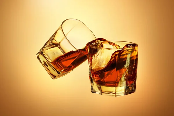 Due bicchieri di whisky che si stringono insieme sul marrone — Foto Stock