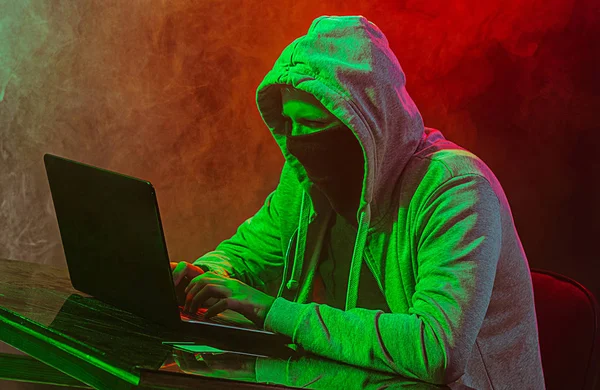 Hacker de computador com capuz roubando informações com laptop — Fotografia de Stock