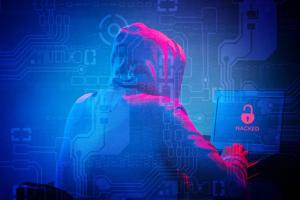 Zakapturzony haker komputerowy kradnie informacje z laptopem — Zdjęcie stockowe