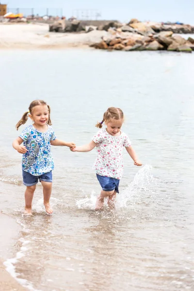Dzieci na brzegu morza. Twins będzie wzdłuż wody morskiej. — Zdjęcie stockowe