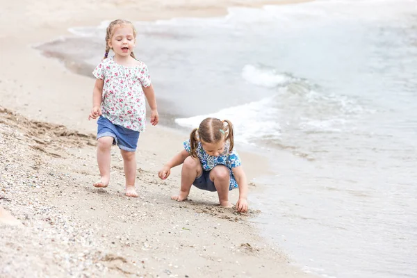 Dzieci na brzegu morza. Twins będzie wzdłuż wody morskiej. — Zdjęcie stockowe