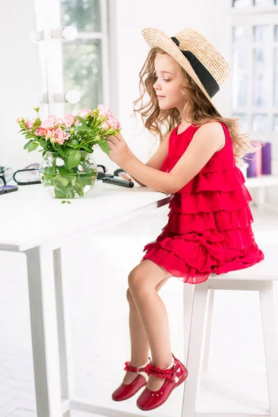 Ein kleines Mädchen mit Kosmetik. sie sitzt im Schlafzimmer der Mutter neben dem Spiegel. — Stockfoto