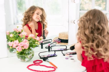 Kozmetik ile küçük bir kız. Annenin odası, aynaya oturan değil.