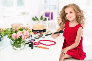 Kozmetik ile küçük bir kız. Annenin odası, aynaya oturan değil.