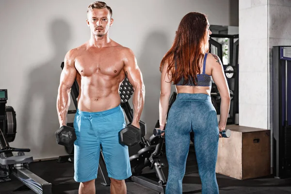 Sport en forme couple à la salle de gym. travailler en paires avec des haltères — Photo