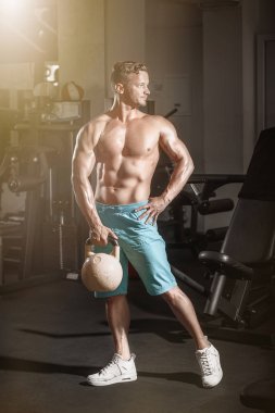 Kaslı vücut geliştirmeci adam ile spor salonunda ağırlık egzersizleri yapıyor