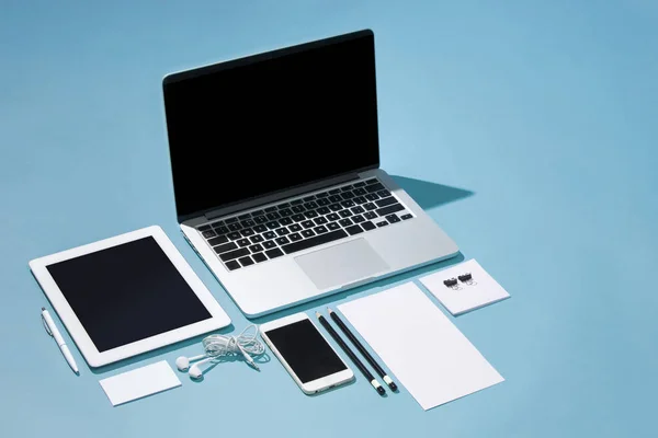 El portátil, bolígrafos, teléfono, nota con pantalla en blanco en la mesa — Foto de Stock