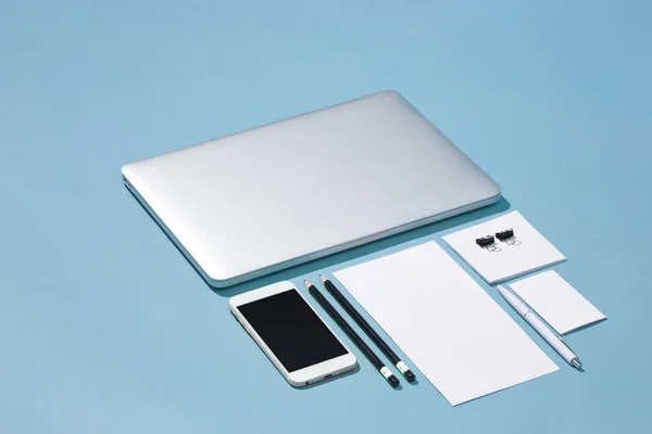 Il computer portatile, le penne, il telefono, la nota con schermo vuoto su tavolo — Foto Stock