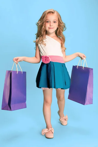 A linda menina morena caucasiana no vestido segurando sacos de compras — Fotografia de Stock