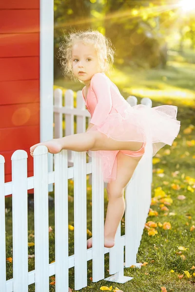 La niña en el patio contra el parque o el bosque verde — Foto de Stock