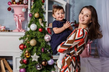 Noel süslemeleri ile stüdyoda mutlu annesiyle küçük kız