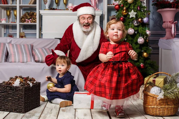 As duas meninas com Papai Noel no estúdio com decorações de Natal — Fotografia de Stock