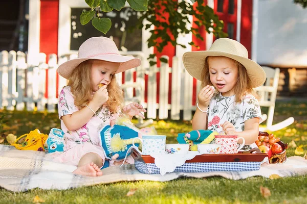 Twee kleine meisjes zitten op groen gras — Stockfoto