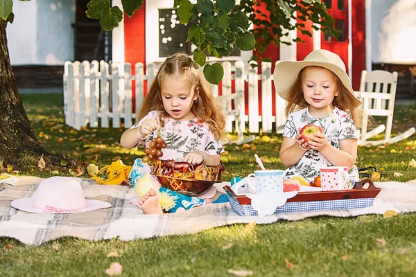 Yeşil çimenlerin üzerinde oturan iki küçük kız