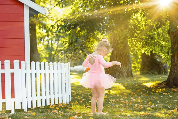 La niña en el patio contra el parque o el bosque verde — Foto de Stock