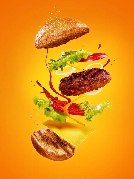 Hamburger z latania składników na pomarańczowym tle — Zdjęcie stockowe