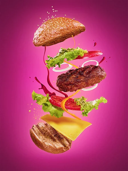 The hamburger with flying ingredients on lilac background