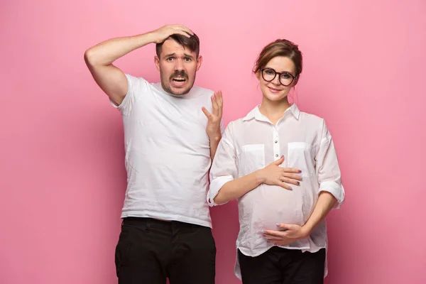 Vtipné překvapení pohledný muž a jeho krásná těhotná wifes bříško — Stock fotografie
