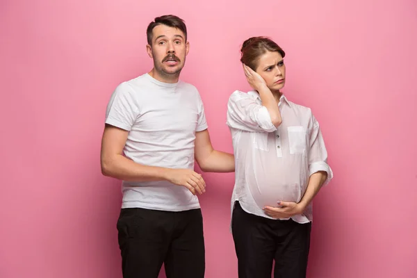 Der lustig überraschte gutaussehende Mann und seine schönen schwangeren Frauen Bauch — Stockfoto