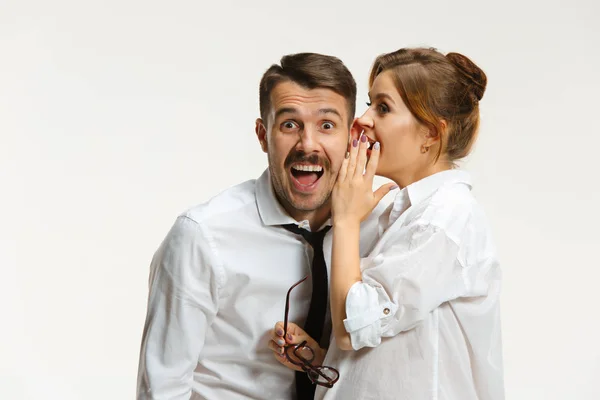 El hombre y la mujer de negocios que se comunican sobre un fondo gris —  Fotos de Stock