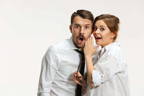 Der Geschäftsmann und die Geschäftsfrau, die auf grauem Hintergrund kommunizieren — Stockfoto