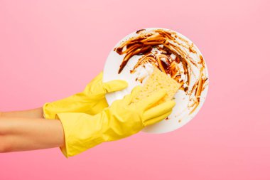 Elinde bir tabak yıkama sarı koruyucu eldivenler