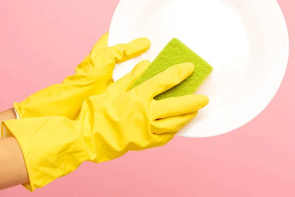 Mãos em luvas de proteção amarelas lavando uma chapa — Fotografia de Stock