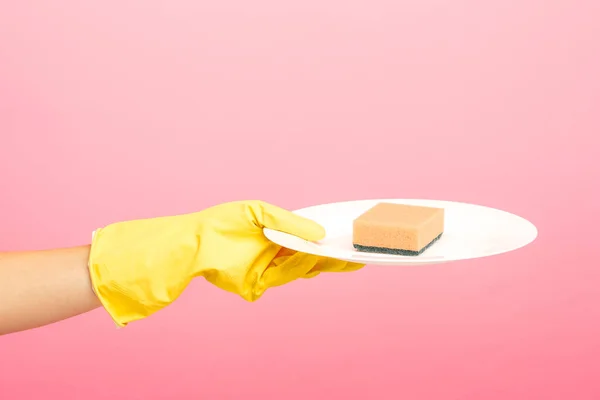 Manos en guantes protectores amarillos lavando un plato — Foto de Stock