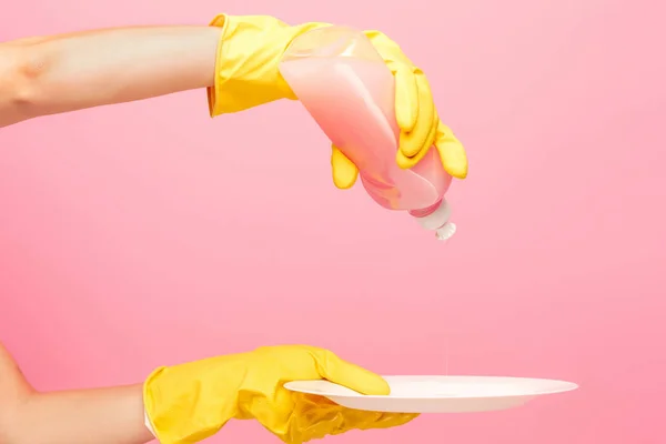 Manos en guantes protectores amarillos lavando un plato — Foto de Stock