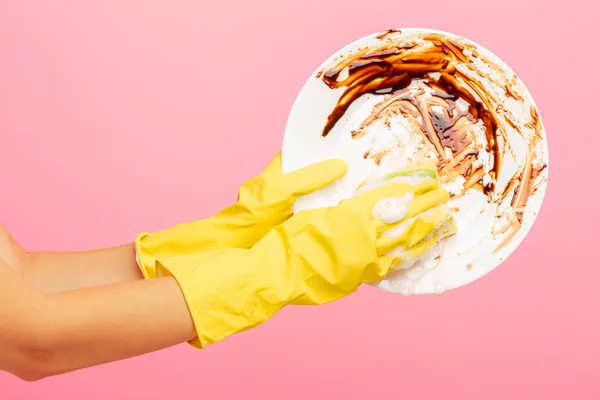 Manos en guantes protectores amarillos lavando un plato — Foto de Stock