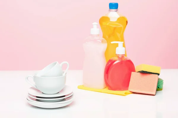 Plusieurs assiettes, une éponge de cuisine et une bouteille en plastique avec lave-vaisselle naturel savon liquide utilisé pour le lavage des mains . — Photo