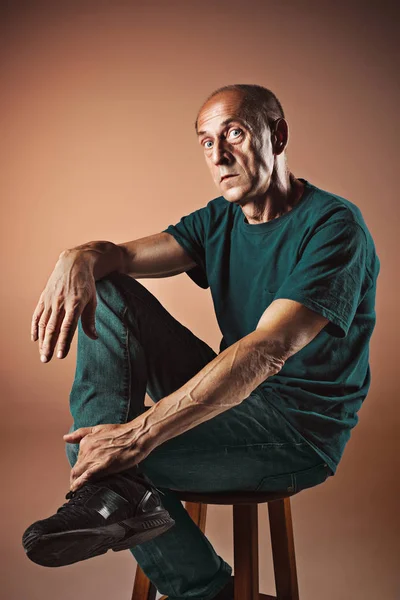 Stüdyoda oturan endişeli olgun adam