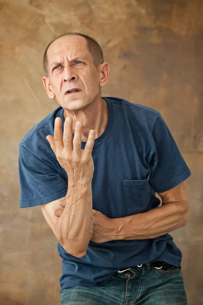 Preoccupato uomo maturo in piedi in studio — Foto Stock